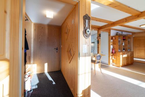 een kamer met houten lambrisering en een hal met een tafel bij Steirüti 15 in Wildhaus