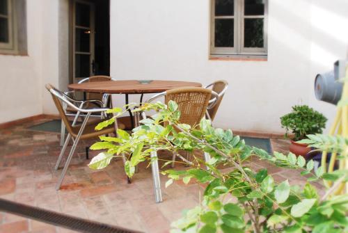 einen Holztisch und Stühle auf einer Terrasse in der Unterkunft Ca la Merce Batista in Palau-Saverdera