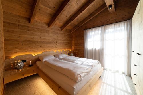 a bedroom with a bed in a wooden wall at Chalet Zuestoll in Wildhaus