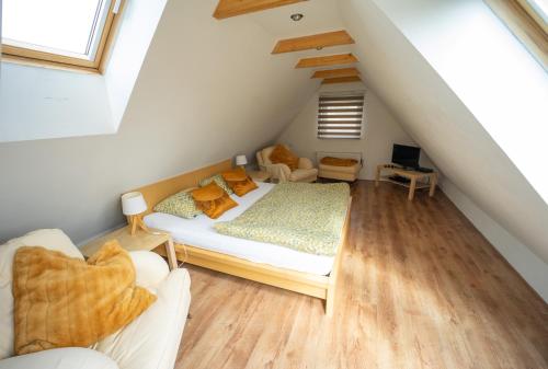 a attic bedroom with a bed and a couch at Villa Maximus in Jáchymov