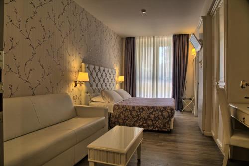 レカナーティにあるHotel Palazzo Belloのソファとベッド付きのホテルルーム