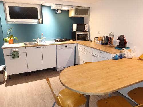 卡萊帕涅的住宿－Tik69，厨房配有木桌、桌子和水槽。