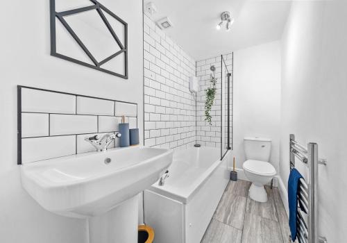 a white bathroom with a sink and a toilet at Garturk Apartment by Klass Living Coatbridge in Coatbridge