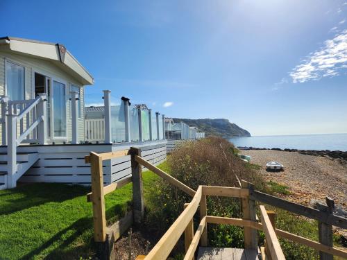 a house on the beach with a wooden fence at Pemberton Avon pitch 30 Creek Caravan Park dog friendly in Ringstead