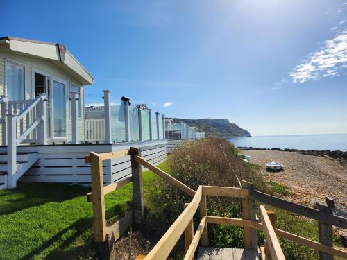 a house on the beach with a wooden fence at Pemberton Avon pitch 30 in Ringstead