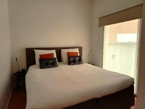 1 cama con 2 almohadas y ventana en Urban Condo - peacefull and cozy spot in historical center, en Amberes