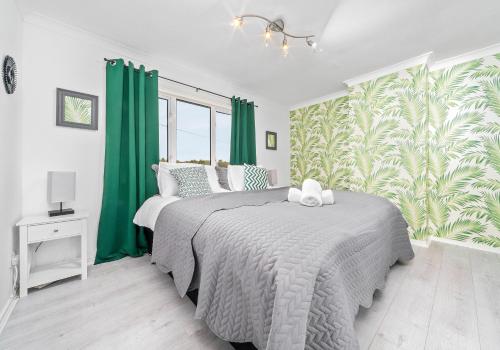 una camera da letto con un grande letto con tende verdi di Rothesay House by Klass Living Coatbridge a Coatbridge