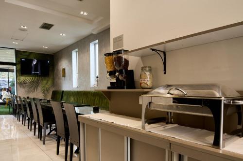 a restaurant with a bar with chairs and a counter at Garni Boutique Hotel Arta in Novi Sad