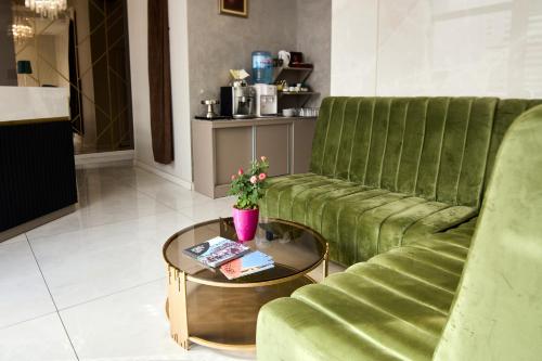 a living room with a green couch and a coffee table at Garni Boutique Hotel Arta in Novi Sad