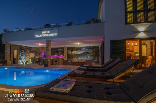 una casa con piscina por la noche en Villa Four Seasons, heated pool and 3 en-suite bathrooms en Velika Cista