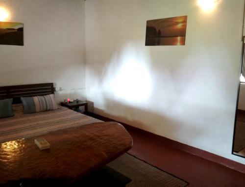 a bedroom with a bed and a white wall at Mamagoa Beach Resort in Mandrem