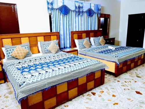 two beds sitting next to each other in a bedroom at Galaxy Inn in Karachi