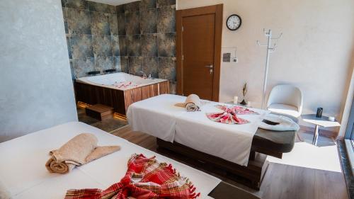a room with two beds and a bath tub at Motel Heksapolis in Tavşancıl