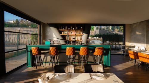 a restaurant with a green bar with orange stools at Motel Heksapolis in Tavşancıl