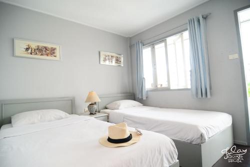 a room with two beds with a hat on top of them at Fulay Guesthouse Hua Hin in Hua Hin