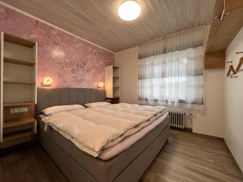 a bedroom with a large bed and a window at Astrid's Appartements in Winterberg