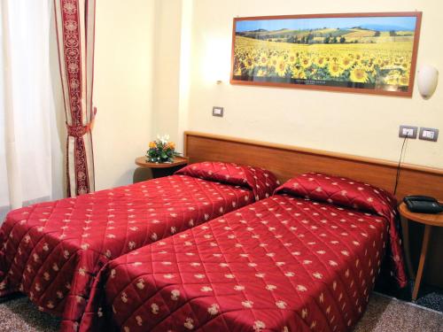 a hotel room with a red bed and a painting on the wall at Hotel Helvetia in Genova