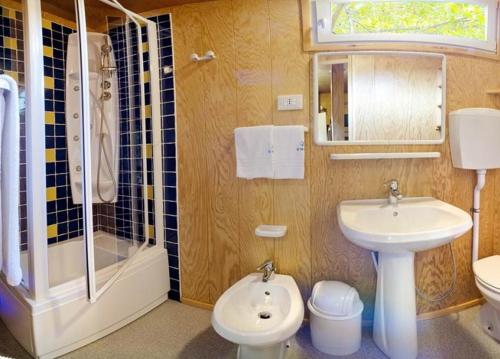 a bathroom with a sink and a shower and a toilet at Il Tridente Camping Village in Bibione