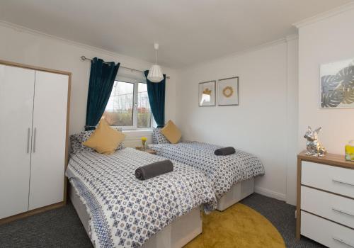 1 Schlafzimmer mit 2 Betten und einem Fenster in der Unterkunft Kenmar House by Klass Living Hamilton in Hamilton