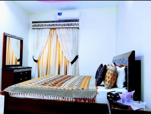 a bedroom with a bed with a mirror and a window at Galaxy Inn in Karachi
