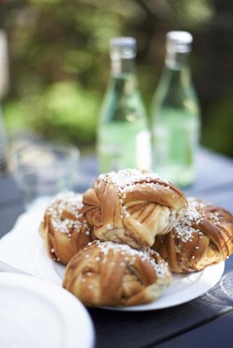 a plate of pastries on a table with two bottles at STF Hotell Rum Oscar in Oskarshamn