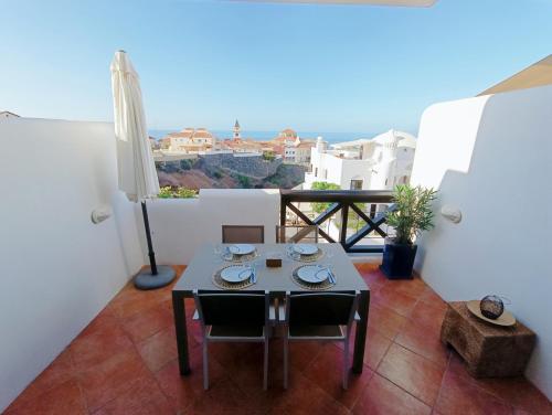 a room with a table and chairs on a balcony at Idaira Paradise in Playa Paraiso