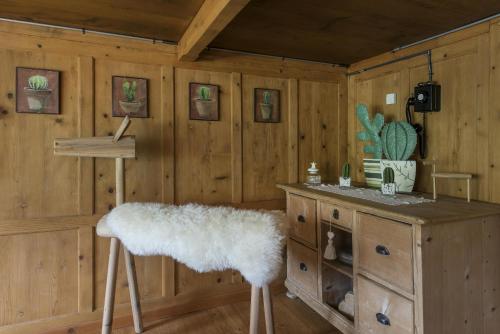 a room with wooden walls and a table and a stool at Landhuus Toggi in Alt Sankt Johann