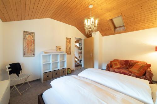 a bedroom with a large white bed and a chandelier at Lisa in Wildhaus