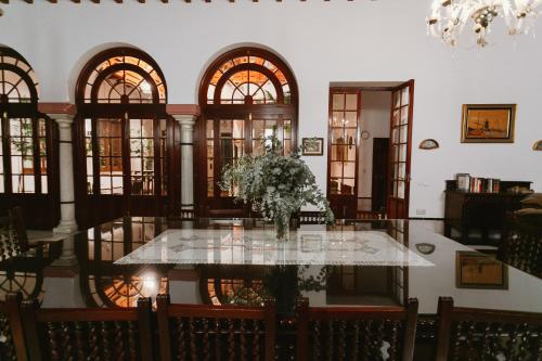 a dining room with a table with a vase of flowers at One & Lux Casa Maravilla in Seville