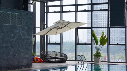 a light hanging over a pool in a room with windows at Serviced apartment Luxury in Vinhomes Westpoint in Hanoi