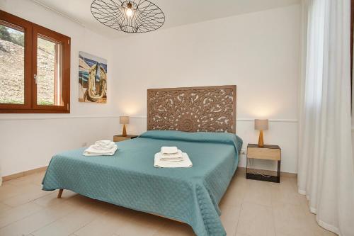 a bedroom with a bed with two towels on it at Villa dell'Artista in Scopello