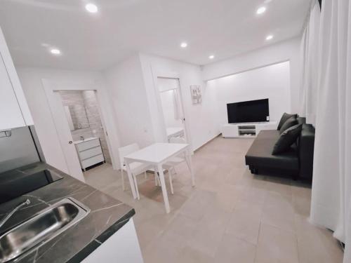 a living room with a black couch and a table at Apartamento 1 vista mar, Las Américas, Costa Adeje, sx in Playa de las Americas