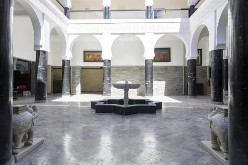 a museum with a fountain in the middle of a room at Hôtel Calipau Riad Maison d'Hôtes in Dakhla