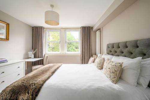 - une chambre avec un grand lit blanc et une fenêtre dans l'établissement Castle View Hideaway, à Édimbourg