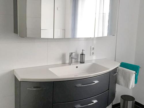 een badkamer met een wastafel en een spiegel bij Haus Burgblick in Badenweiler