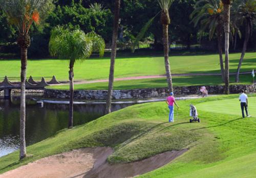 un par de personas jugando golf en un campo de golf en Siriana Suites 101, 001, en Benalmádena