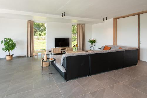 a living room with a couch and a tv at Fluithoekhoeve in Koksijde