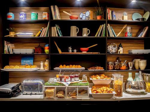 a shelf filled with lots of food on a counter at Novotel Paris Rueil Malmaison in Rueil-Malmaison