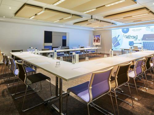 a large conference room with a large table and chairs at Novotel Paris Rueil Malmaison in Rueil-Malmaison