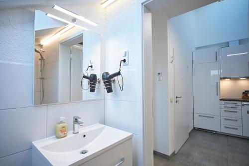 uma casa de banho branca com um lavatório e um espelho em Schaefer Apartments - Residence Green Garden em Offenbach