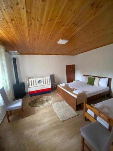 地拉那的住宿－VILA DISHA，一间卧室设有两张床和木制天花板