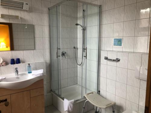 ein Bad mit einer Dusche und einem Waschbecken in der Unterkunft Gasthaus Klosterhof 
