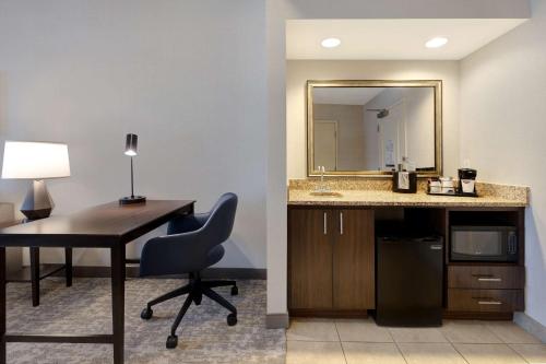Habitación con escritorio con silla y espejo. en Hampton Inn & Suites San Luis Obispo, en San Luis Obispo