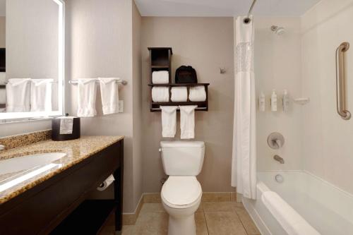 a bathroom with a toilet and a tub and a sink at Hampton Inn & Suites San Luis Obispo in San Luis Obispo