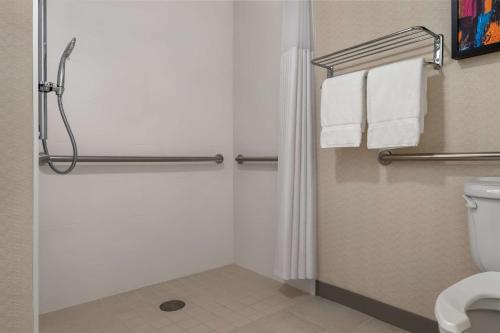 a bathroom with a shower and a toilet with towels at Hilton Garden Inn Montgomery East in Montgomery