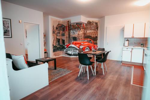 una sala de estar con una mesa y un coche rojo en la pared en Vienna Shopping Center 14 Apartment, en Viena