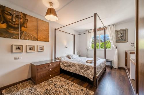 een slaapkamer met een hemelbed en een raam bij Evamas in Palma de Mallorca