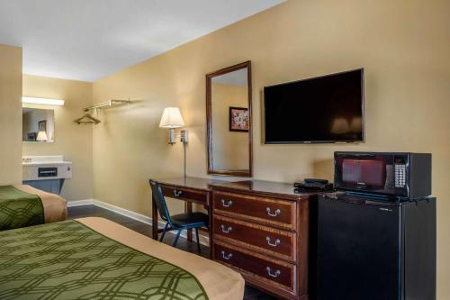 a hotel room with a desk with a television and a bed at Econo Lodge Union City - Atlanta South in Union City