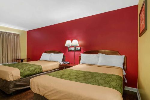 a room with two beds and a red wall at Econo Lodge Union City - Atlanta South in Union City
