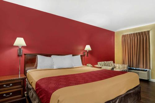 a hotel room with a bed and a red wall at Econo Lodge Union City - Atlanta South in Union City